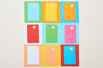 top view of multicolored empty credit cards on grey background
