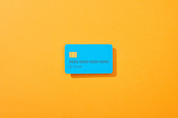 top view of blue credit card template on orange background