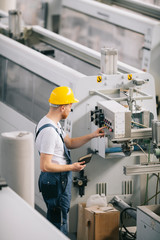 Man with helmet working in factory.
