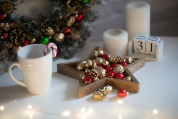Christmas morning. Christmas toys, cup of coffee and christmas wreath on a white wooden table....
