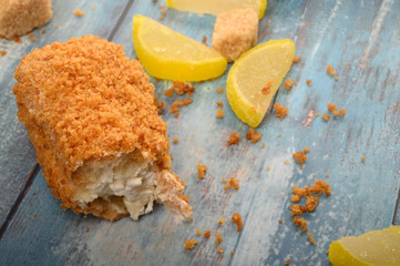 One broken cake, pieces of brown sugar and marmalade lemon slices on a wooden background.