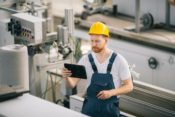 Man with helmet working in factory.