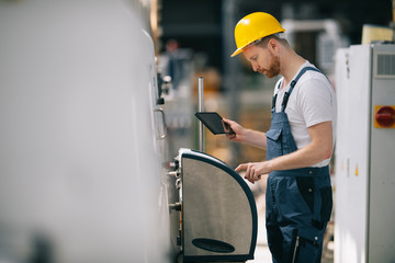 Man with helmet working in factory.