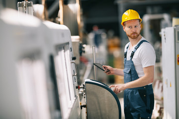Man with helmet working in factory.