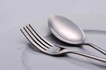 fork and silver spoon on white plate