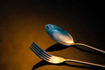 fork and silver spoon on dark background