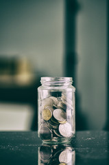 financial concept,coin in transparent glass jar over shallow depth of field background