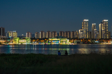 Night view of buildings, apartment, bridge and floating islands from opposite of Han river bank in Seoul, Korea. 