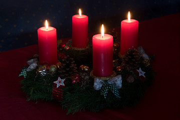 advent wreath with four lighted red candles, romantic atmosphere