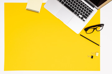School and office supplies lie neatly on a yellow background