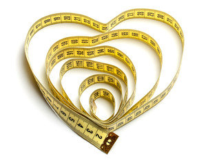 Heart made of yellow measuring tape isolated on white background