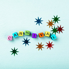 Festive turquoise background with colorful cubes with text Carnival. Greeting card concept voor carnival and party. Copy space, top view, flat lay. Banner