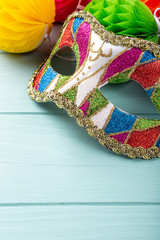 Festive blue background with colorful carnival mask and peper balls. Greeting card concept voor...