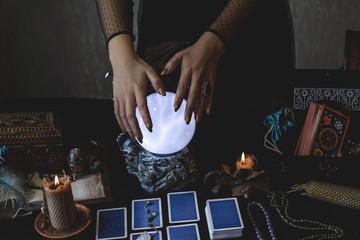 Tarot cards and crystal ball, candles, witch magic bottles . Wicca, esoteric, divination and occult background with vintage magic objects for mystic rituals