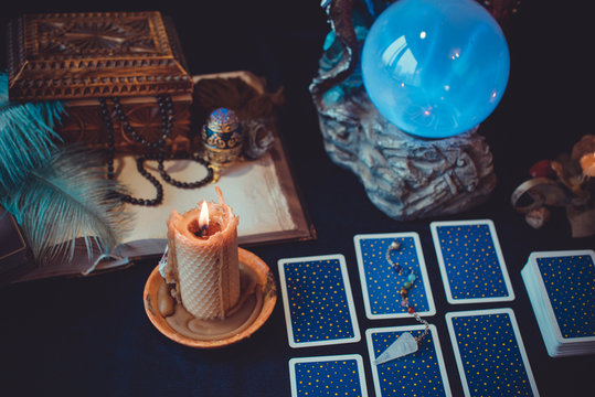 Tarot cards and crystal ball, candles, witch magic bottles . Wicca, esoteric, divination and occult background with vintage magic objects for mystic rituals