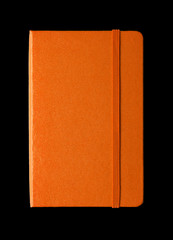 Orange closed notebook isolated on black