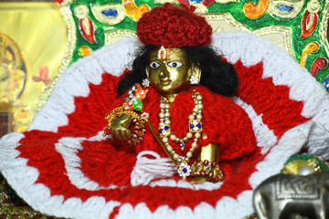 Fototapeta premium Lord Krishna idol wrapped in a warm costume at Govardhan temple during the winter in Beawar, Rajasthan, India. Photo/Sumit Saraswat