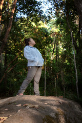 Relaxing in Nature : Asian woman standing on the forest. Chubby woman enjoying relaxing in the wild