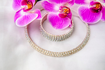 Bracelet and necklace on white fabric and purple Orchid