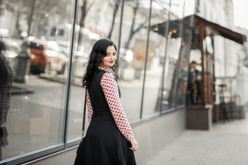 Obraz premium Beautiful woman in fashionable clothes walking through the streets of the city.