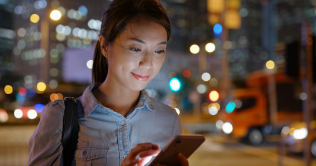 Woman use of mobile phone in city at night