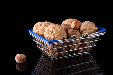 miniature food basket with nuts on black background