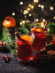 Two glasses of traditional Christmas and winter hot drink mulled wine of red wine with cinnamon, anise, berries and orange
