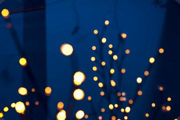 holidays abstract garland lights unfocused bokeh lamps illumination on dark blue interior background environment