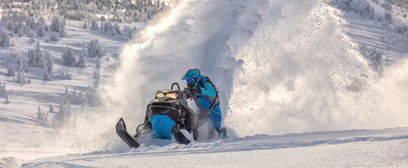 Pro snowmobiler makes a turn and lets a flurry of snow spray from under the caterpillar. sports...