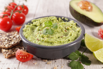 homemade guacamole with bread, tomato and lime