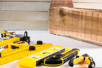 Set of yellow woodworking tools with wooden tool box.