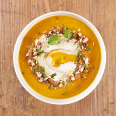 pumpkin soup with cream and nuts in bowl