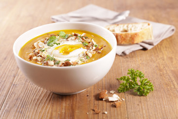 pumpkin soup with cream and nuts in bowl