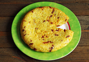 Tasty omelette on plate on wood