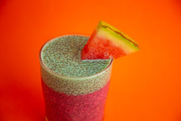 Glass of black chia pudding with watermelon taste