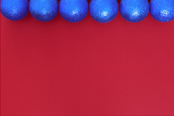 Christmas composition with copy space. New year balls or bubles blue decorations on paper red background. Christmas, winter, concept. Flat lay, top view.