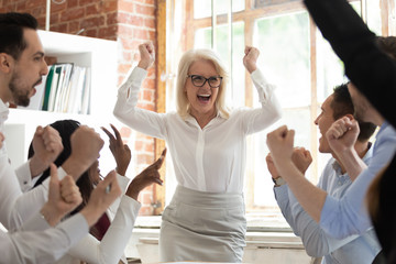 Team celebrating corporate success screaming with joy feels happy