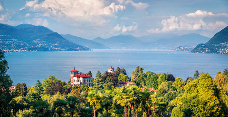 Old houses are buried in a sea of green in Stresa town. Picturesque summer view of Maggiore lake,...