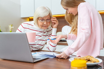 Fototapeta premium Focused elderly lady leaning over the document