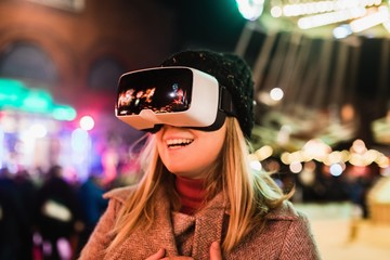 Beautiful smiling female experiencing unbelievable feelings with VR glasses