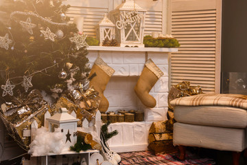 Decorated Christmas fireplace near fir-tree with inscription "Merry Christmas" on white wall background