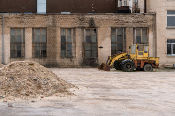 Fototapeta na wymiar Old buldozer in the yard of abandoned factory