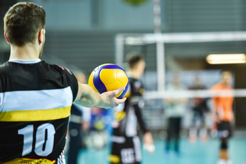 Volleyball player holds the ball before the service