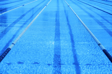 Classic blue Olympic swimming pool with competition lanes. Toned color of the year 2020 trendy blue...