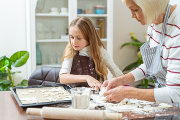 Fototapeta na wymiar Woman and a child making cookies at home