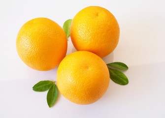 Above of ripe oranges are bright yellow with green leaves isolated on white background.