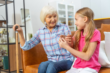Woman with a cane smiling at her grandchild
