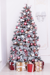 Beautiful Christmas tree decorated with toys and gift boxes