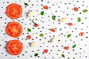 Pattern of vegetables. Food background. Composition of tomatoes, chili peppers, parsley, garlic and spices on white background. Top view.