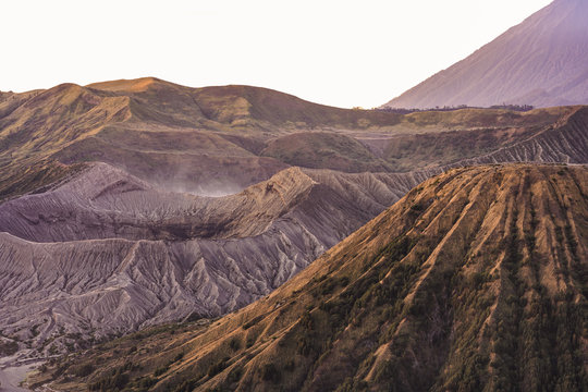 View from above, stunning aerial view of the Mount Batok, Mount Bromo and the Mount Semeru in the distance illuminated at sunrise, East Java, Indonesia.